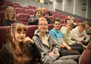 Uczniowie siedzacy w sali kinowe zdjecie zbiorowe