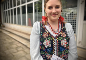 Uczennica Tischnerówki ubrana w strój góralski rozdaje ulotki szkoły