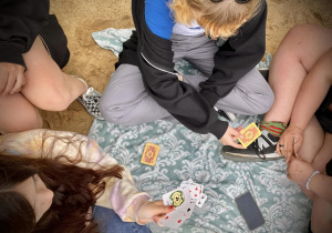 Rekreacja po spacerze uczniowie grają w karty na plaży w Arturówku