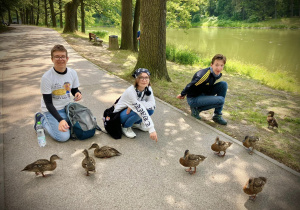 Uczniowie karmią kaczki w Arturówku