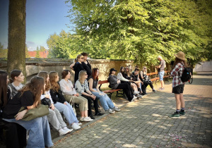 Uczniowie siedzą na ławkach pod kościołem w Łagiewnikach