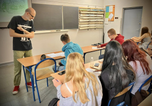 Pan Piotr Kasiński rozmawia z uczniem podczas zadania na warsztatach z tworzenia komiksu