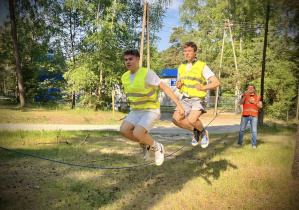 Uczniowie skaczą przez linę wykonując zadanie sportowe