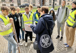 Uczniowie słuchają zadania stojąc przy ulicy Kościuszki