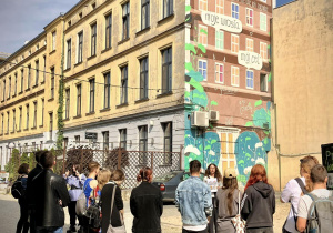 Uczniowie pod muralem reklamowym na ulicy Piotrkowskiej 217