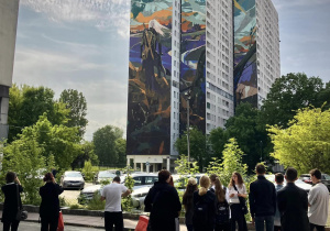 Uczniowie stoją pod muralem Wiedźmina na Łodzkim manhatanie