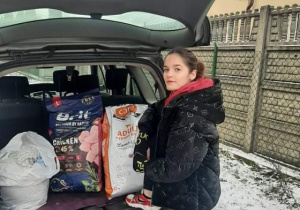 Uczennica klasy 3MG Maja Dudek przy samochodzie z prezentami dla schroniska