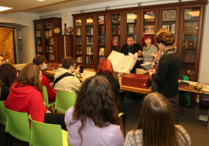 Uczniowie klasy 1UA podczas zajęć w bibliotece słuchają wykładu.
