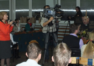 Na pierwszym planie operator kamery z TV.